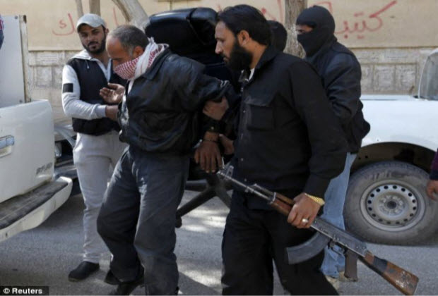 Islamist Syrian rebel group Jabhat al-Nusra hold a detainee as they transport him in Raqqa province