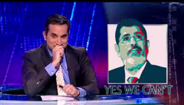 باسم يوسف في حلقة من برنامج البرنامج مع صورة الرئيس المصري محمد مرسي 