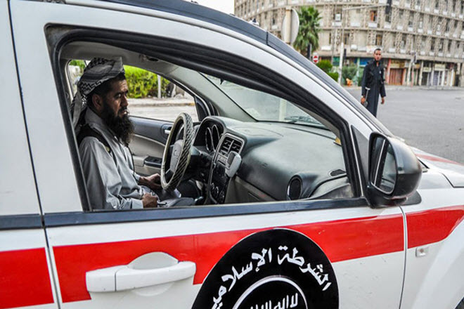 أحد عناصر الشرطة الإسلامية التاتابعة لداعش يقود إحدى سيارات الشرطة في الموصل