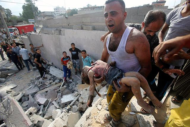 رجل يحمل جثة طفلة فلسطينية قتلت في غارة جوية اسرائيلية في خان يونس في جنوب قطاع غزة