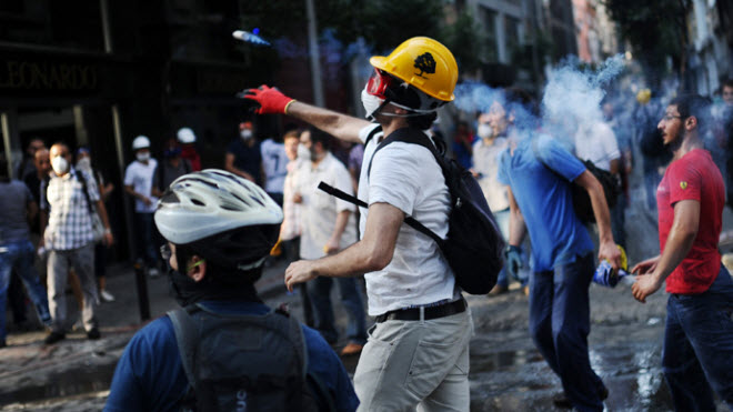 متظاهر يرجع قنبلة مسيلة للدموع على شرطة مكافحة الشغب خلال اشتباكات بين الشرطة والمتظاهرين في إسطنبول